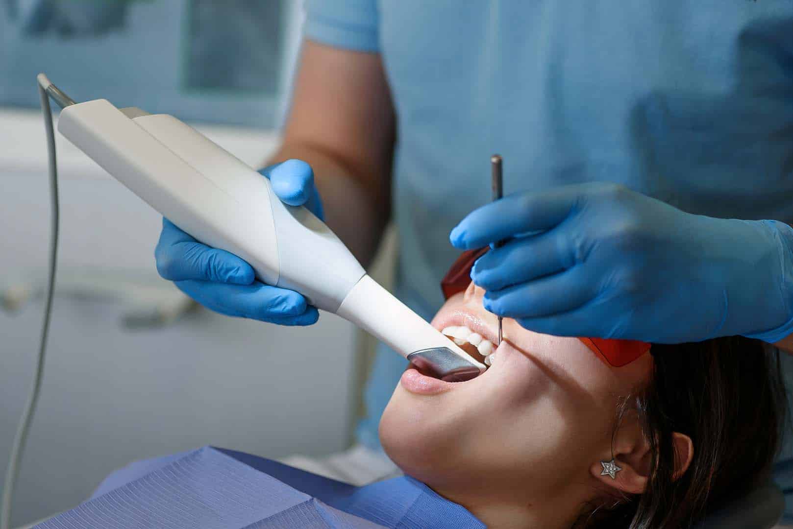 The dentist scans the patient's teeth with a 3d scanner.