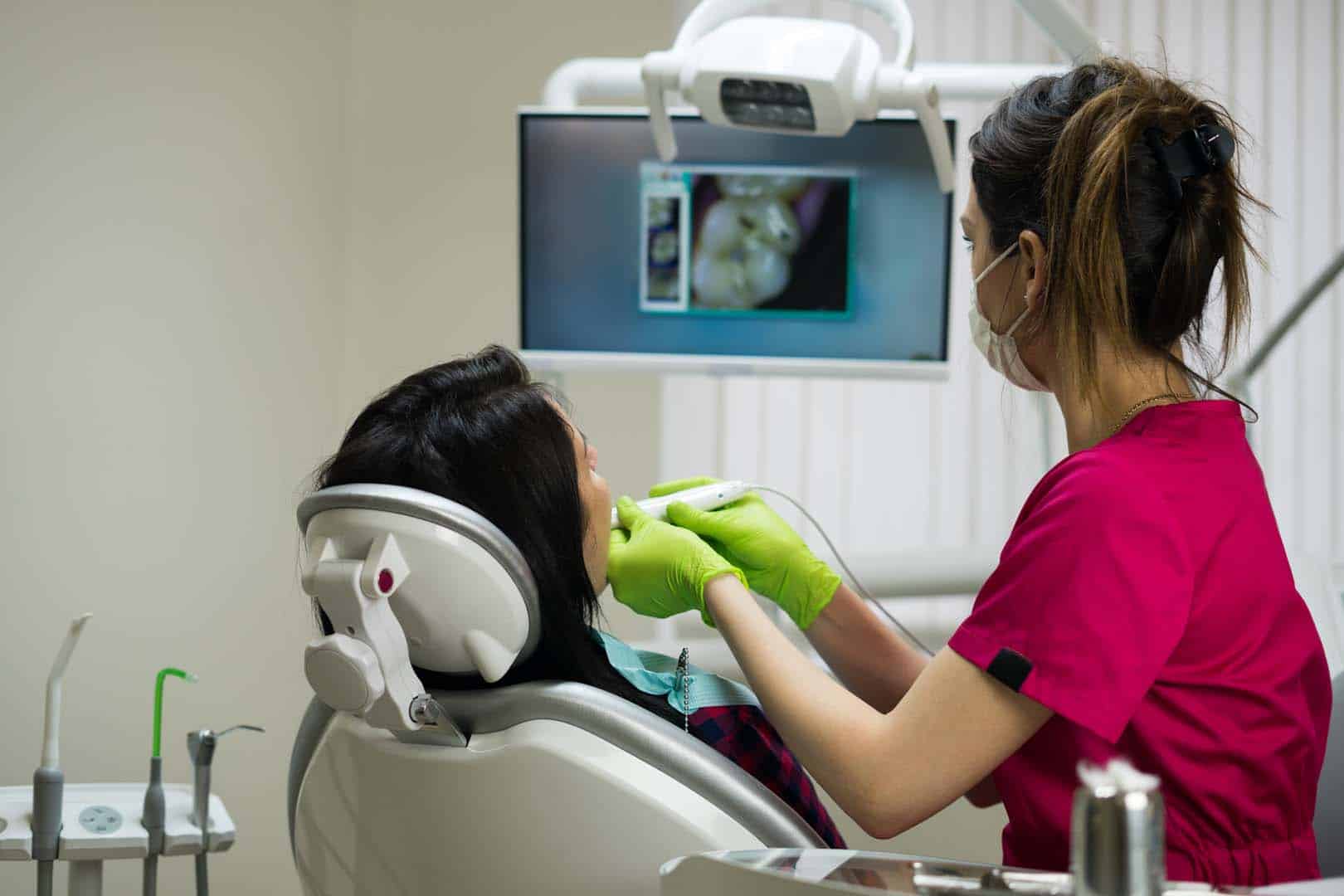 Dentist examining woman's teeth with camera