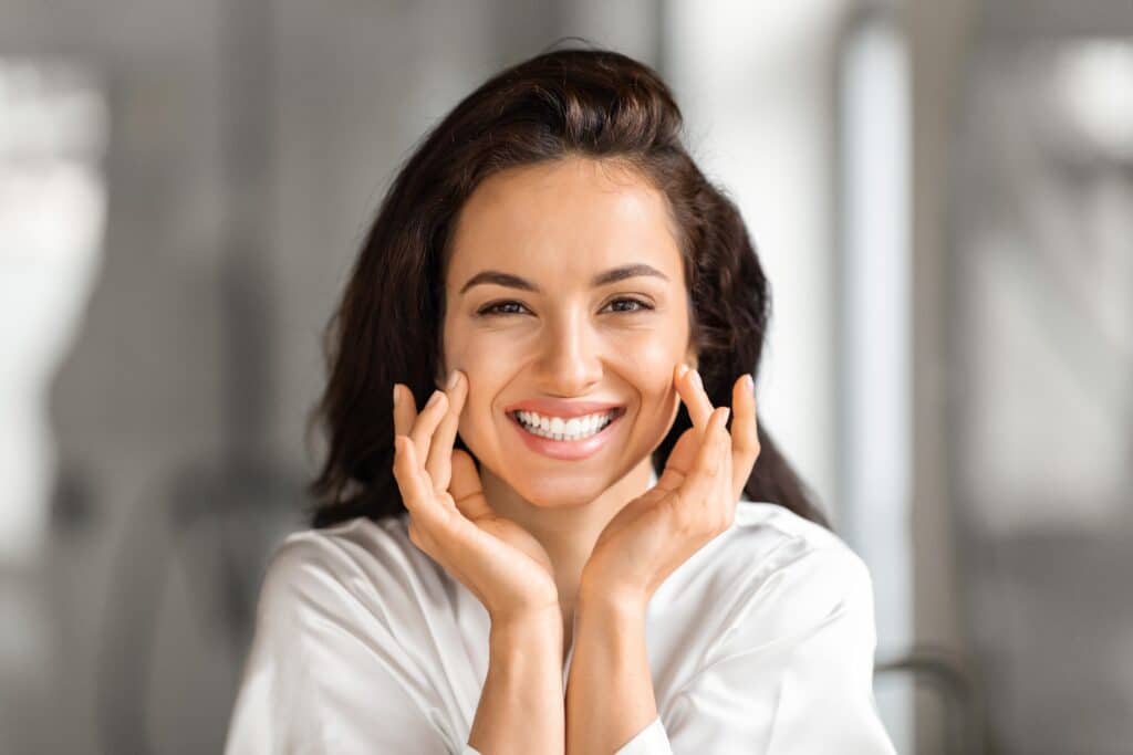 Woman with beautiful, complete smile after getting single-tooth implant